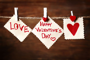 Valentine's Day card with hearts and words of love on wooden background