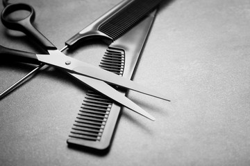 Barber set with two combs and scissors on grey background
