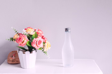 flower and bottle of water, on white table