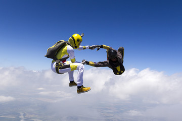 Two sports parachutist build a figure in free fall.
