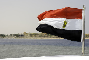 Flag of Egypt on background of sea and shore.