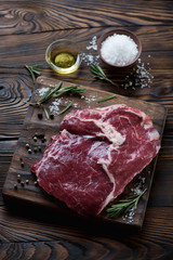 Raw fresh rancho beefsteak on a rustic wooden chopping board