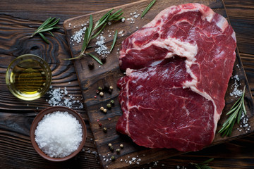 Above view of raw rancho beefsteak with seasonings, close-up