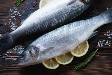 Close-up of fresh uncooked sea-bass with lemon and seasonings