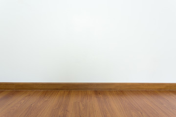 empty room with brown wood laminate floor and white mortar wall