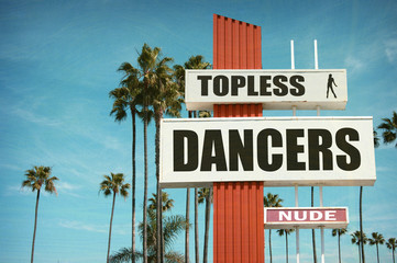 aged and worn vintage photo of topless dancer sign