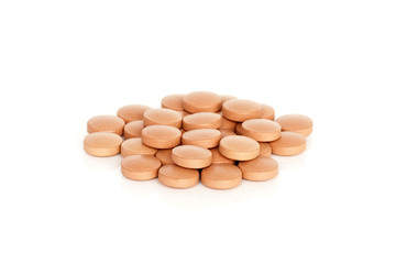 Iron Vitamin Tablet Supplements. A pile of iron vitamin supplement tablets isolated on a white background.