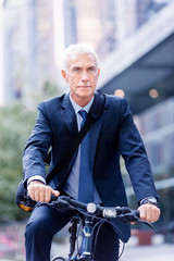 Fototapeta premium Successful businessman riding bicycle