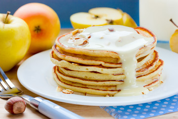 Pancakes with apples, nuts and syrup for breakfast