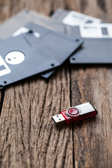 USB storage drive and floppy disks on a wooden table