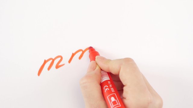 Hand of woman writing goal mmm on paper