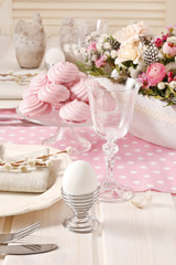White egg and pink meringues on the easter table