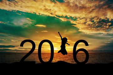 Silhouette young woman jumping on the sea and 2016 years while celebrating new year