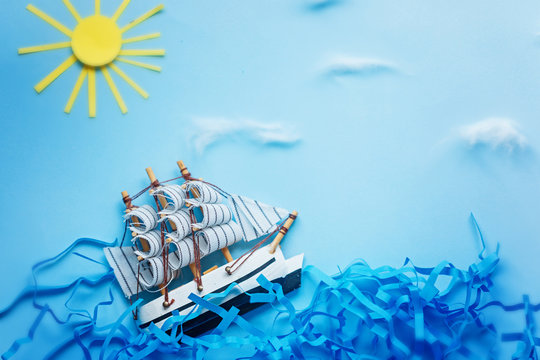 White Ship on blue wave with paper and sun. Travel and adventure concept