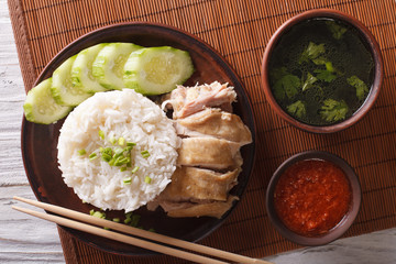 Hainanese chicken rice close-up, chili sauce and broth. horizontal top view
