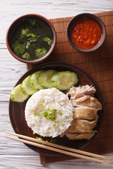 Hainanese chicken rice close-up, chili sauce and broth. vertical top view
