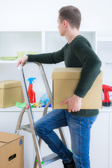 mann steht mit karton auf der leiter