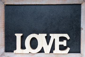 Love / Wooden blackboard with wooden letters and the word Love