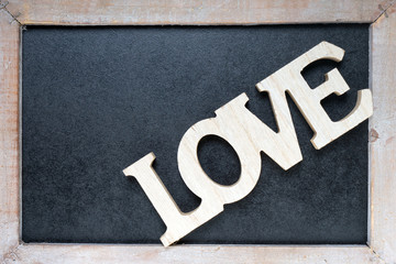 Love / Wooden blackboard with wooden letters and the word Love