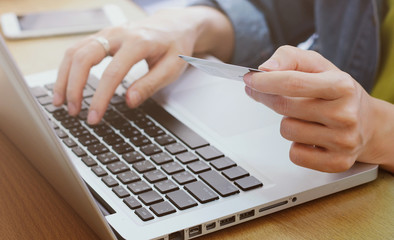 Woman’s hands holding credit card and using laptop, online sho