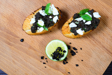 bruschetta Tapenade, with olives on old wooden Board