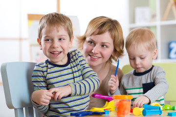 Family molded from clay toys. Mother play with children.