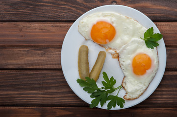 Fried eggs in a plate on a wooden background
