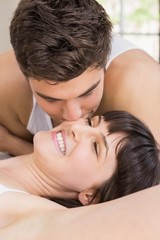 Obraz na płótnie Canvas Man kissing woman on bed