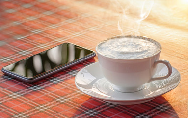 Coffee, cappuccino and black smart phone.