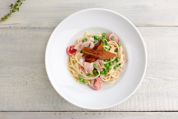 plate of pasta bacon, cheese, cherry tomatoes