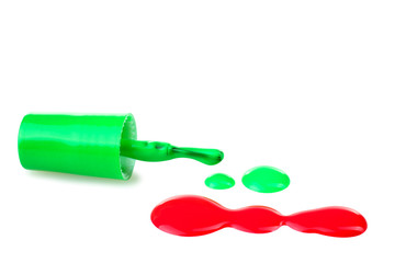 green and red nail Polish near brush a little bit spilled on a white isolated background