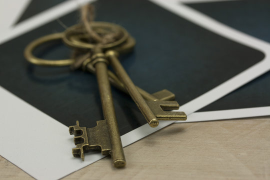 Old keys and photographs on a rustic background