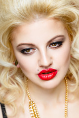 Portrait of beautiful blonde glam rocker woman on orange background. Closeup of Beauty Woman face make up. Bright make-up with sexy red lips and perfect skin