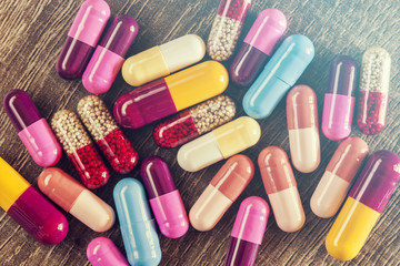 Mix of colorful capsules on a wooden surface