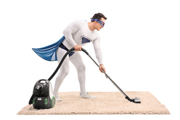 Young superhero vacuuming a carpet