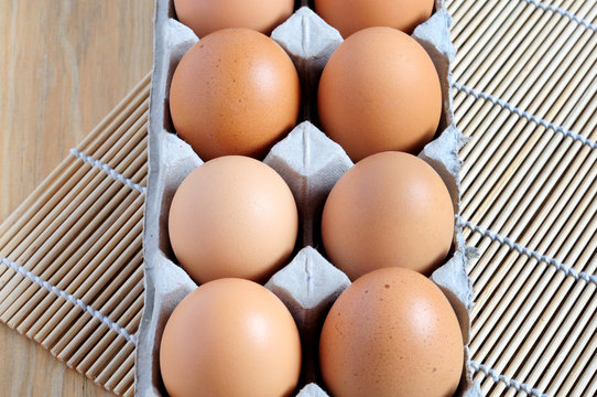 Directly view from above of an eggs on a tray with wooden table