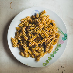 dish full of fusilli,  italian type of pasta on white background, mushrooms and peppers