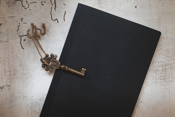 vintage key  and butterfly on black minimal notebook, vintage style