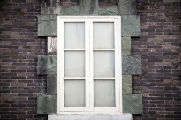 White window in brick wall from outside.