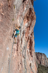 Mature male extreme Climber moving up on rocky Wall