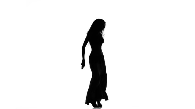 Talanted long-haired exotic belly dancer girl go on dance on white, silhouette