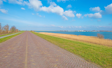 Road over a dike along a lake in winter