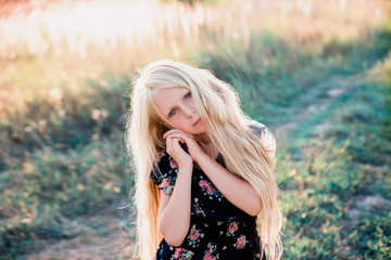Naklejka premium Portrait of a baby girl spinning in a field in sunset light, life style