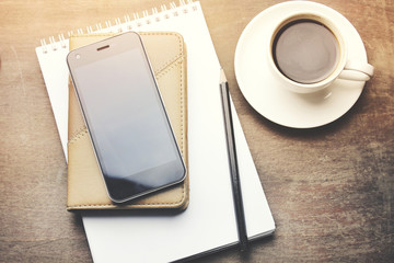 paper on notebook on phone and coffee on table © ARAMYAN