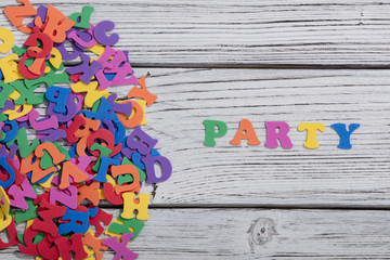 the colorful words party made with colorful letters over white wooden board