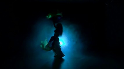 Beautiful exotic belly dancer woman continue dance, uses fans, on black, slow motion, silhouette, smoke