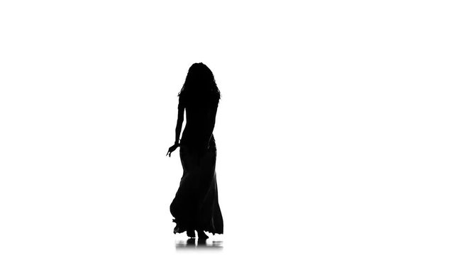Beautiful exotic belly dancer woman, shaking her hips, on white, slow motion, silhouette
