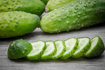 Cucumber on gray wooden surface texture.