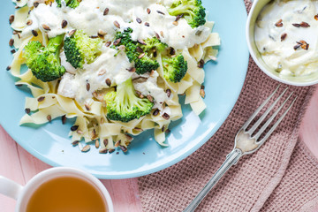 Pasta dish broccoli sauce sunflower seeds