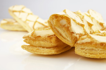 Confectionery theme. Puff a cookies, topped with honey on a bright surface.